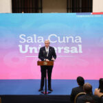 Presidente Kast habla desde un podio. Atrás de él una gigantografía azul y rosada con el texto "Sala Cuna Universal".