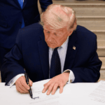 Intereses de Teherán prevalecen en el acuerdo Irán-EE.UU. Donald Trump firmando un documento sobre una mesa con mantel blanco.
