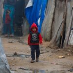 Niño camina entre las carpas de refugiados de Gaza.