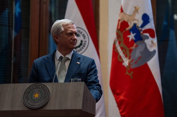 Presidente José Antonio Kast tras un podio. Detrás de él se ven las banderas de Chile y Paraguay.