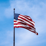Estados Unidos en sus 250 años: luces y sombras de una nación imperial Bandera de Estados Unidos en un cielo despejado.