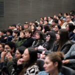 Cuarta versión del Mes de la Red Salas de Cine convocó a casi 4 mil espectadores en salas independientes de Chile Espectadores en una sala de cine. La luz esta prendida y varios miran al frente sonriendo.