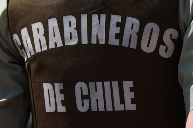 Parte trasera de un chaleco verde de Carabineros, que dice "Carabineros de Chile".