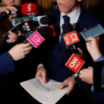 Comunicación Política: la mitad que no controlamos Político o autoridad dando declaraciones a la prensa rodeado de micrófonos de medios chilenos como TVN, Canal 13, CNN Chile, CHV y Radio ADN.