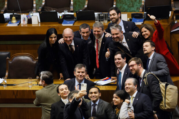 Parlamentarios oficialistas celebrando la aprobación de la megarreforma en la Cámara de Diputadas y Diputados junto al ministro Jorge Quiroz.