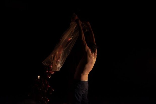 Ensayo de una escena del montaje, en medio de una atmósfera oscura.