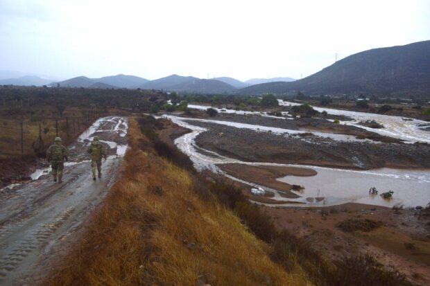 Personal militar patrullando un camino de tierra inundado junto al desborde de un río o quebrada en la región de Coquimbo.