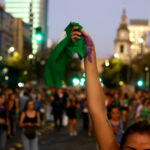 Organizaciones en antesala del pañuelazo contra "Escucha su corazón": “No será el Congreso quien defienda nuestros derechos” Manifestante alzando un pañuelo verde en una concentración masiva en la calle durante la Marcha 8M.