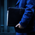 Gobierno espera "punto de inflexión" en desempleo y expertos advierten alza de la informalidad Plano detalle de hombre con traje y una carpeta negra.