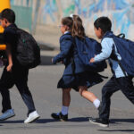 Estudiantes preescolares cruzando una calle.