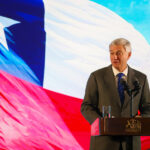 Salida de los No Alineados: el costo de acercarse a Washington sin garantías de reciprocidad Presidente José Antonio Kast da discurso desde un podio y con una bandera de Chile que cubre todo el fondo.