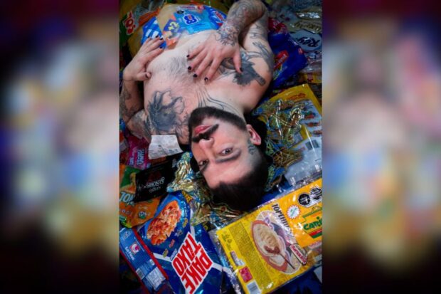Daniel Bagnara recostado entre numerosos envases y paquetes de dulces.