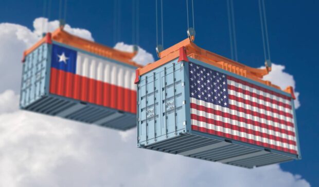 Dos contenedores alzados en el cielo, uno con la bandera de Chile y otro con la de Estados Unidos.