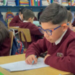 65% de los estudiantes de 3° básico presenta dificultades lectoras: ¿qué impacto tienen y cómo fortalecer su comprensión? Niño leyendo en una sala de clases.