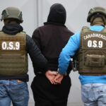 Secuestros superan los 800 casos anuales: Fiscalía advierte que niveles siguen muy por encima de 2021 Dos carabineros llevan esposado a un sujeto que viste poleron negro.
