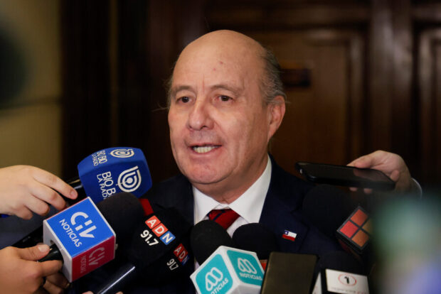 Ministro de Hacienda, Jorge Quiroz, rodeado de micrófonos de distintos medios de comunicación.