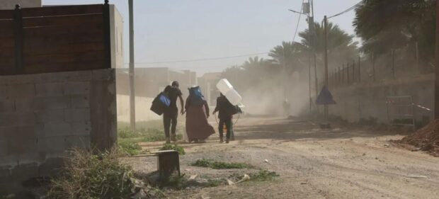 © UNICEF Una familia camina por una calle en Cisjordania cargando sus pertenencias.