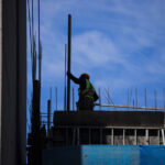 Buscan revertir cifra del 9,5%: Gobierno y partidos preparan propuestas para combatir altos niveles de desempleo Trabajador de la construcción revisa pilares de una obra al aire libre.