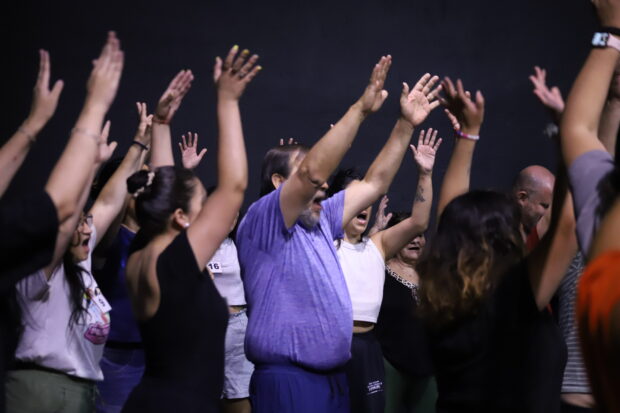 Grupo de personas con los brazos alzados.
