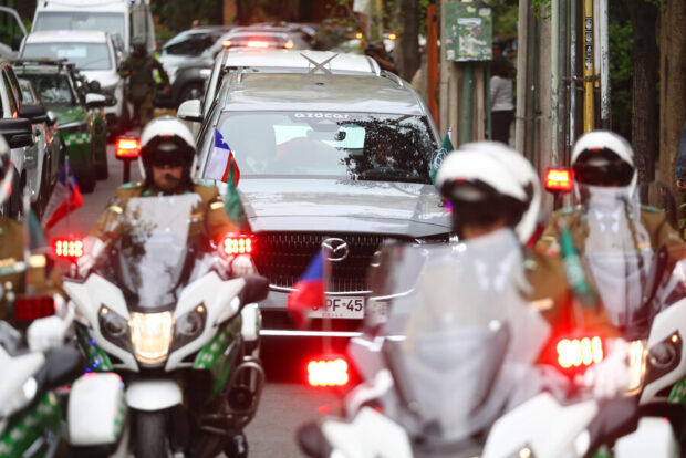 Carroza funebre escoltada por carabineros en motocicleta.