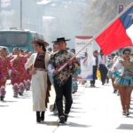 Pareja de huasos desfilan con la bandera chilena en el día del floklore junto a conjuntos y agrupaciones folklóricas,