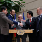 Grupo de senadores estrechan sus manos.