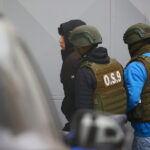 Dos carabineros escoltan a un delincuente detenido.
