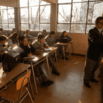 La lágrima del dato: alcances sobre la certificación docente y fracturas pedagógicas en el aula contemporánea Profesor escribiendo en la pizarra frente a estudiantes sentados en sus pupitres.