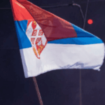 De las calles al poder: el movimiento estudiantil que derrotó a Vučić en Serbia Bandera de Serbia siendo hondeada en las manifestaciones que rodearon al país