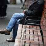Desempleo sube a 9,8%: cerca de 1 millón de personas están sin trabajo Hombre a quien no se le ve el rostro sentado en un banca. Usa un traje y jeans.