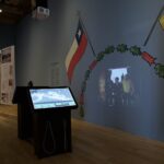 Una historia en curso: Museo de la Memoria inaugura su primera exposición sobre Colonia Dignidad Sala de exhibiciones en el Museo de La Memoria. En la pared hay una bandera de Chile junto a otra de Alemania.